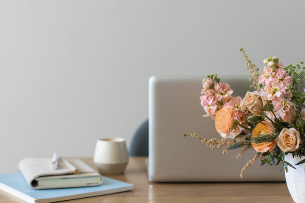 floral arrangement in front of laptop computer on desk ready to work