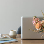 floral arrangement in front of laptop computer on desk ready to work