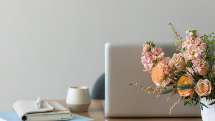 floral arrangement in front of laptop computer on desk ready to work