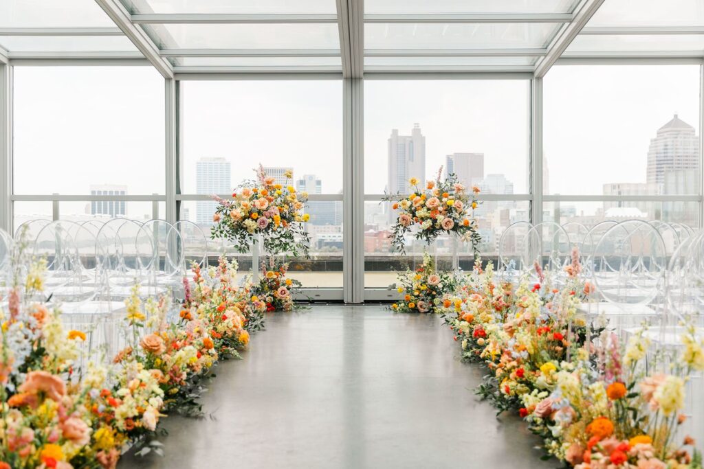 colorful floral lining the aisle of wedding ceremony